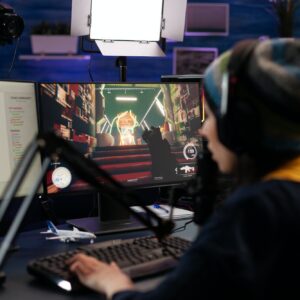 Woman live streaming video games on monitor with chat